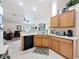 Kitchen with stainless steel appliances, wood cabinets and a view to the living room at 9431 Spring Hill Dr, Spring Hill, FL 34608