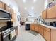 Kitchen with stainless steel appliances, wood cabinets, tile floors and a view to the living room at 9431 Spring Hill Dr, Spring Hill, FL 34608