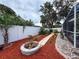The backyard landscaping showcases a rock lined walkway with a small fire pit at 9431 Spring Hill Dr, Spring Hill, FL 34608