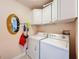 Functional laundry room equipped with a washer, dryer, and storage cabinets for added convenience at 9431 Spring Hill Dr, Spring Hill, FL 34608