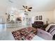 Living room with vaulted ceilings, ceiling fan, tile floors, view to kitchen and breakfast bar at 9431 Spring Hill Dr, Spring Hill, FL 34608