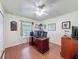 Well-lit office with hardwood flooring, a large desk, and a view to the hallway and bedroom at 9431 Spring Hill Dr, Spring Hill, FL 34608