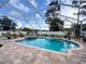 Gorgeous screened-in pool with spa, surrounded by lush landscaping for a private retreat at 9431 Spring Hill Dr, Spring Hill, FL 34608