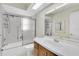 Bathroom featuring a shower-tub combination with glass doors, and a wood vanity at 9433 Stonewall Ln, New Port Richey, FL 34655