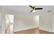 Living room leading into kitchen with ceiling fan and wood floors at 9433 Stonewall Ln, New Port Richey, FL 34655