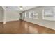 Open living area with wood laminate flooring, ceiling fan, and multiple windows at 9433 Stonewall Ln, New Port Richey, FL 34655