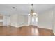 Spacious living room features hardwood floors and a decorative chandelier, with double entry doors at 9433 Stonewall Ln, New Port Richey, FL 34655