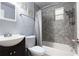 Bathroom featuring a shower with gray stone-look tile, and a white sink and toilet at 9635 Century Dr, Spring Hill, FL 34608