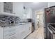 Modern kitchen featuring stainless steel appliances, white cabinets, and elegant granite countertops at 9635 Century Dr, Spring Hill, FL 34608