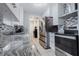 Modern kitchen with stainless steel appliances, granite countertops and white cabinets at 9635 Century Dr, Spring Hill, FL 34608