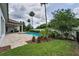 Expansive backyard featuring a sparkling pool, lush lawn, mature trees, and meticulous landscaping at 9704 Milano Dr, Trinity, FL 34655