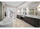 Bright bathroom features a soaking tub, marble floors, and dual vanities at 9704 Milano Dr, Trinity, FL 34655