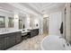 Elegant bathroom with dual vanities, soaking tub, and glass-enclosed shower at 9704 Milano Dr, Trinity, FL 34655