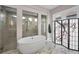 Stylish bathroom featuring a soaking tub, glass-enclosed shower, and elegant tile work at 9704 Milano Dr, Trinity, FL 34655