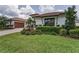 Charming home featuring a well-manicured lawn, lush landscaping, a brick driveway, and a tiled roof at 9704 Milano Dr, Trinity, FL 34655