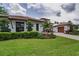 Charming home featuring a well-manicured lawn, lush landscaping, a brick driveway, and a tiled roof at 9704 Milano Dr, Trinity, FL 34655