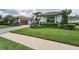 Charming home featuring a well-manicured lawn, lush landscaping, a brick driveway, and a tiled roof at 9704 Milano Dr, Trinity, FL 34655