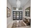Grand foyer features a dazzling chandelier, elegant console table, and beautiful tile flooring at 9704 Milano Dr, Trinity, FL 34655