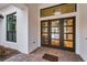 Stunning front entry features a glass door, beautiful lighting, and attractive hardscaping at 9704 Milano Dr, Trinity, FL 34655