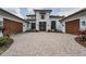 Elegant home with a beautiful paved driveway, manicured landscaping, and a grand entrance at 9704 Milano Dr, Trinity, FL 34655
