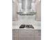Close up of kitchen range with stainless steel hood and white marble tile backsplash at 9704 Milano Dr, Trinity, FL 34655