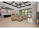 Open-concept living room with elegant furniture, a decorative ceiling, and seamless access to the modern kitchen at 9704 Milano Dr, Trinity, FL 34655