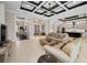 Open-concept living room with coffered ceiling flows seamlessly into the kitchen and dining areas at 9704 Milano Dr, Trinity, FL 34655