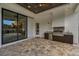 Covered outdoor kitchen featuring wooden cabinets, granite countertops, and a stainless-steel grill on a paved patio at 9704 Milano Dr, Trinity, FL 34655