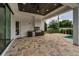 A covered outdoor kitchen with stainless steel appliances overlooks the backyard with partial views of a pool at 9704 Milano Dr, Trinity, FL 34655