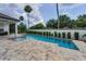 Gorgeous pool with a tanning ledge complemented by a well-manicured yard, perfect for outdoor enjoyment at 9704 Milano Dr, Trinity, FL 34655