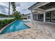 Inviting pool with expansive patio and outdoor kitchen, set against a backdrop of lush landscaping at 9704 Milano Dr, Trinity, FL 34655
