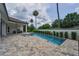 Stunning pool with a tanning ledge, surrounded by lush landscaping and a spacious patio area at 9704 Milano Dr, Trinity, FL 34655