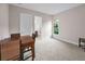 Neutral room featuring a dining area, carpeted flooring, and a well-lit bathroom just through an open doorway at 9704 Milano Dr, Trinity, FL 34655