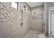 Elegant tiled shower featuring mosaic accents, multiple shower heads, and natural light at 9704 Milano Dr, Trinity, FL 34655