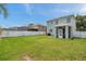 Large backyard with manicured lawn, screened in patio, and white picket fence at 9706 Simeon Dr, Land O Lakes, FL 34638