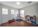 Well-lit bedroom with wood-look floors and two windows, offering a flexible space at 9706 Simeon Dr, Land O Lakes, FL 34638