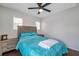 Bright bedroom featuring wood-look floors and natural light from two windows at 9706 Simeon Dr, Land O Lakes, FL 34638