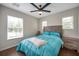 Cozy bedroom offers wood-look flooring, natural light, and ceiling fan at 9706 Simeon Dr, Land O Lakes, FL 34638