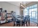 Dining area featuring stylish light fixture, view to backyard through sliding glass doors, and display shelves at 9706 Simeon Dr, Land O Lakes, FL 34638