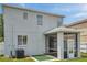 Back exterior of the house with view of the screened in patio and air conditioning unit at 9706 Simeon Dr, Land O Lakes, FL 34638