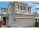 Close up of a two car garage with arched windows and a garden at 9706 Simeon Dr, Land O Lakes, FL 34638