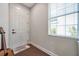 Bright foyer with wood-look tile flooring, a large window and a white front door at 9706 Simeon Dr, Land O Lakes, FL 34638
