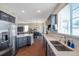 Modern kitchen with stainless steel appliances, quartz countertops, and view into the dining room at 9706 Simeon Dr, Land O Lakes, FL 34638