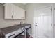 Functional laundry room with modern washer, dryer, cabinets, and a door at 9706 Simeon Dr, Land O Lakes, FL 34638