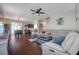 Open-concept living room featuring a leather sectional, ceiling fan, and adjacent dining area at 9706 Simeon Dr, Land O Lakes, FL 34638