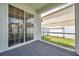 A screened in patio with sliding glass doors and view of the backyard and fence at 9706 Simeon Dr, Land O Lakes, FL 34638