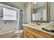 Bright bathroom featuring a tub with shower, light wood vanity, and ornate-framed mirror reflecting the space at 10924 Archway Ave, Hudson, FL 34667