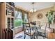 Cozy dining room featuring a glass table, unique chandelier, and large window at 10924 Archway Ave, Hudson, FL 34667