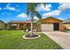 Charming single-story home with a well-manicured lawn, beautiful landscaping, and a brick driveway at 10924 Archway Ave, Hudson, FL 34667