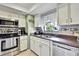 Well-lit kitchen with white cabinetry, stainless steel appliances, and tiled backsplash at 10924 Archway Ave, Hudson, FL 34667